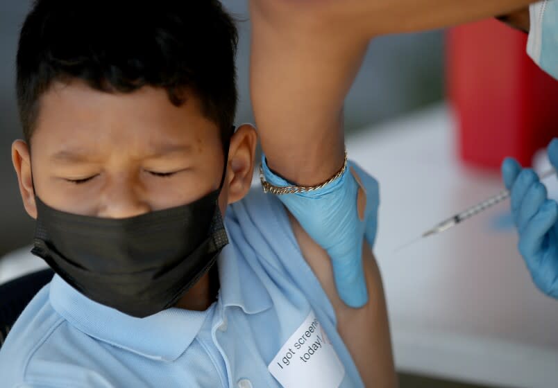 LYNWOOD, CALIF. - MAR. 16, 2022. Paolo Canizales, 10, winces as he gets a shot of the Pfizer vaccine at Hellen Keller Elementary School in Lynwood on Wednesday, Mar. 16, 2022. (Luis Sinco / Los Angeles Times)