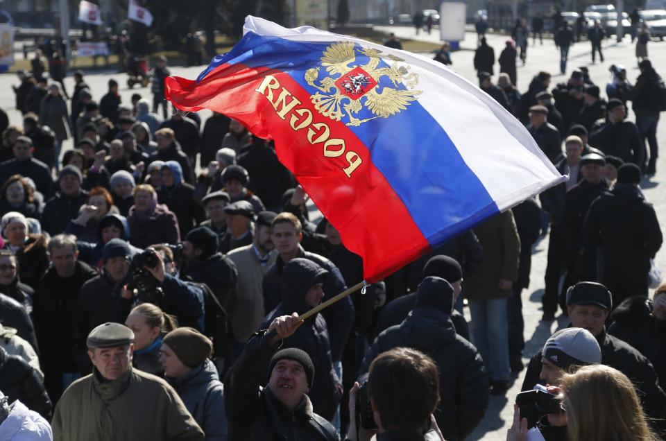 A man waves a Russian flag during a pro Russian rally at a central square in Donetsk, eastern Ukraine, Monday, March 10, 2014. Many Russian-speakers in the region continue to protest against the new Ukrainian government following the overthrow of pro-Kremlin President Viktor Yanukovych. (AP Photo/Sergei Grits)