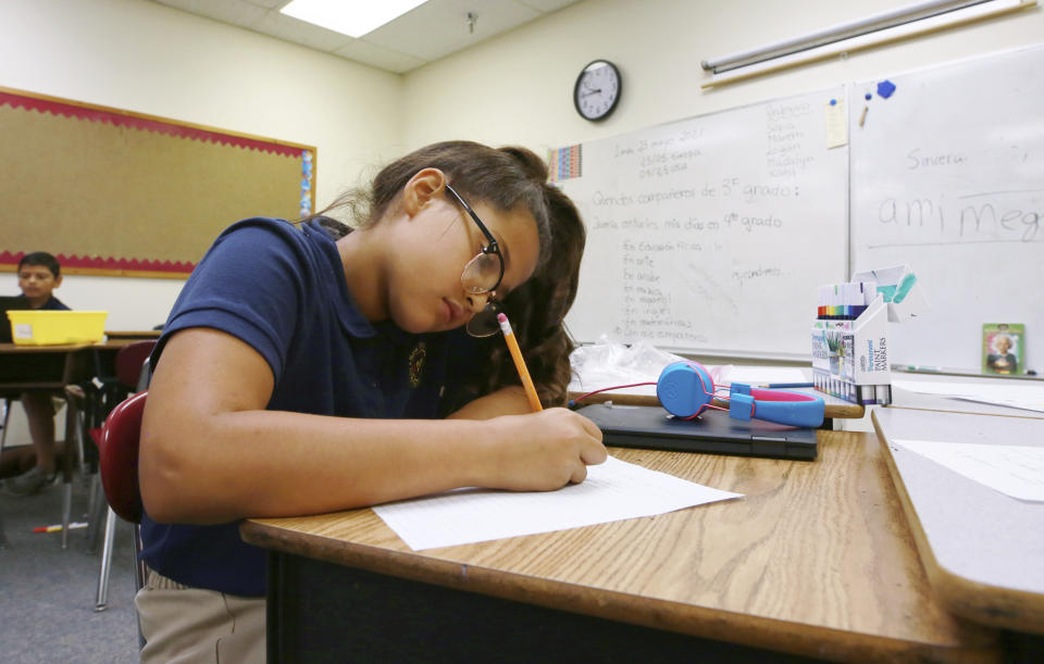 Fourth grade Spanish/English dual language class student Jaqueline Powell, 10, writes her assignment in Spanish at the New Mexico International School in Albuquerque, N.M., on Monday, May 23, 2022. (AP Photo/Cedar Attanasio)
