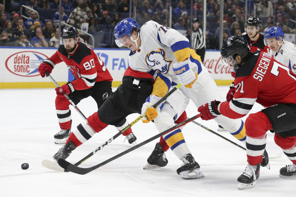 Buffalo Sabres right wing Tage Thompson (72) tries to skate past New Jersey Devils players during the third period of an NHL hockey game Friday, Nov. 25, 2022, in Buffalo, N.Y. (AP Photo/Joshua Bessex)