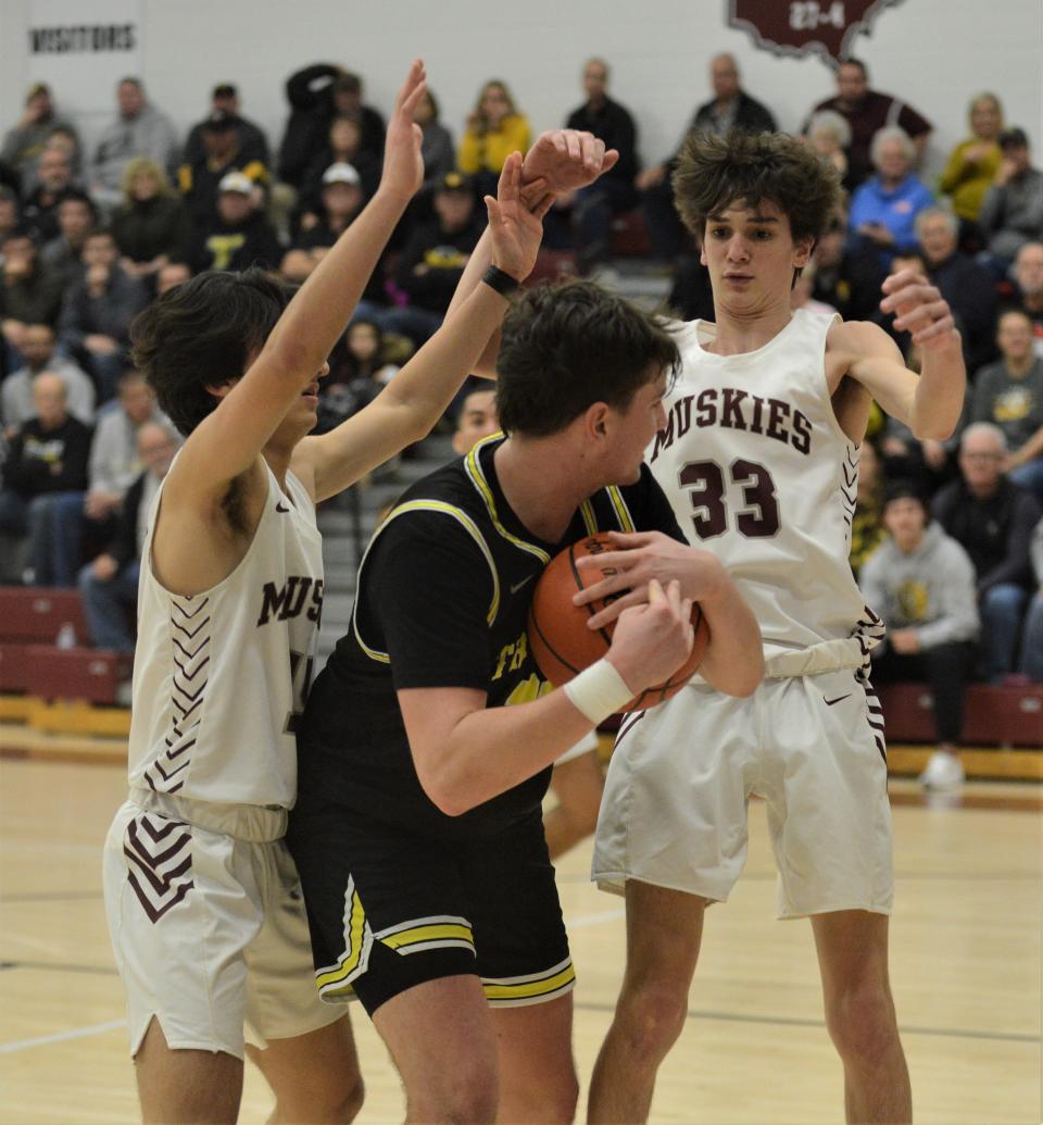 Tri-Valley's Max Lyall is trapped by John Glenn's Will Nicolozakes and Stehl Bates (33) during Tuesday's MVL Big School Division clash. The Scotties won 50-48.