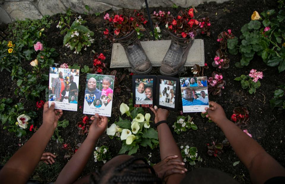 Denise Chandler, 37, of Detroit lost her husband, Richard Chandler when he died March 29 at Sinai-Grace Hospital in Detroit. Denise Chandler holds personalized photos of her late husband with three of her eight children over the memorial garden that includes her husband's work boots.