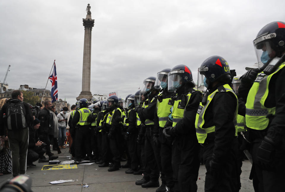 Riot police faces protesters who took part in a 'We Do Not Consent' rally at Trafalgar Square, organised by Stop New Normal, to protest against coronavirus restrictions, in London, Saturday, Sept. 26, 2020. (AP Photo/Frank Augstein)