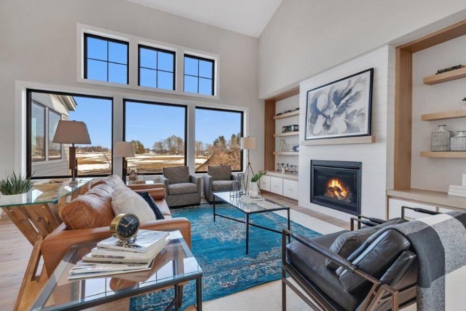 The great room welcomes family and friends with its soaring ceilings. Rift oak built-ins flank the fireplace and floor-to-ceiling, wall-to-wall windows complete the space.