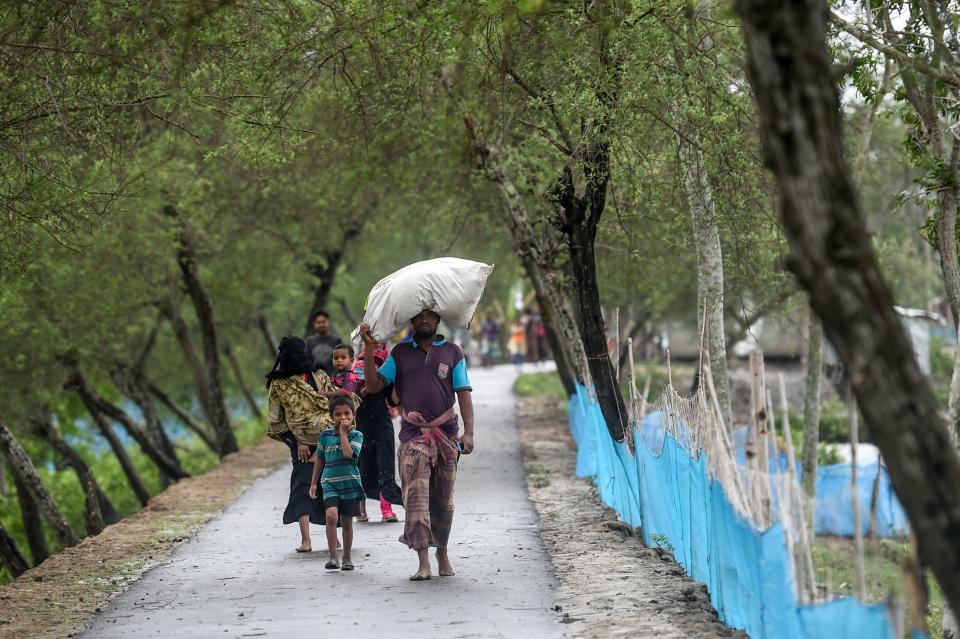 Residents walk along a street heading to a shelter ahead of the expected landfall of cyclone Amphan, in Dacope of Khulna district on May 20, 2020. - Several million people were taking shelter and praying for the best on Wednesday as the Bay of Bengal's fiercest cyclone in decades roared towards Bangladesh and eastern India, with forecasts of a potentially devastating and deadly storm surge. Authorities have scrambled to evacuate low lying areas in the path of Amphan, which is only the second "super cyclone" to form in the northeastern Indian Ocean since records began. (Photo by Munir uz Zaman / AFP) (Photo by MUNIR UZ ZAMAN/AFP via Getty Images)