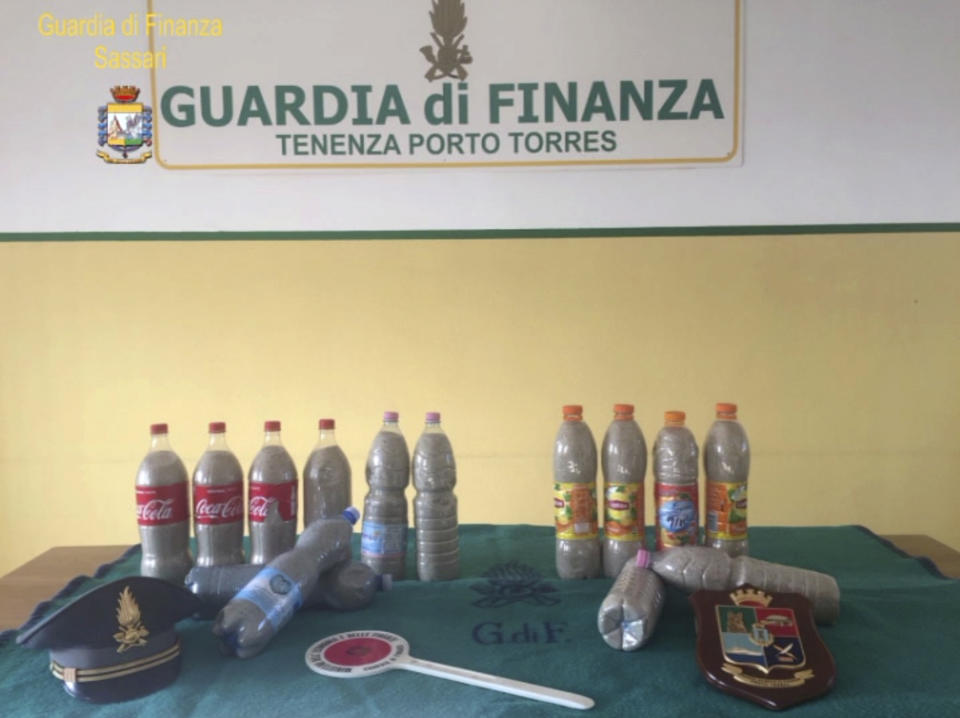 This picture taken on Aug. 16, 2019 by the Finance Police of the Sardinian port of Porto Torres, Italy, shows 14 plastic bottles of sand seized from a French couple in the trunk of the couple’s car. The French couple could face up to six years in jail for taking around 40 kg (88.1lbs) of the island's famed white sand from Chia beach, which is protected as a public good. (Italian Finance Police via AP)