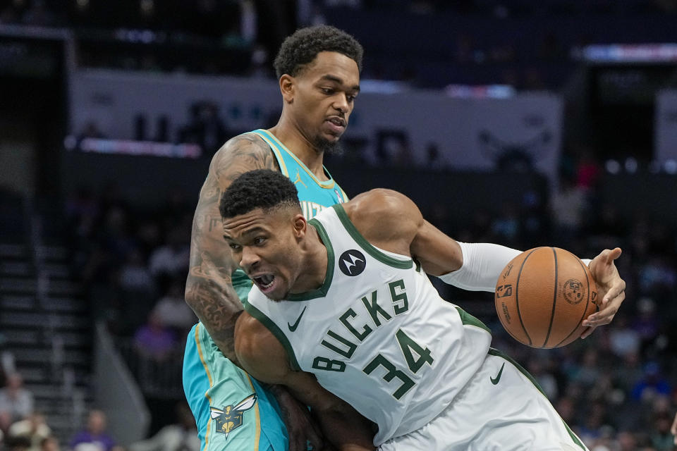 Milwaukee Bucks forward Giannis Antetokounmpo drives to the basket past Charlotte Hornets forward P.J. Washington during the first half of an NBA basketball game on Friday, Nov. 17, 2023, in Charlotte, N.C. (AP Photo/Chris Carlson)