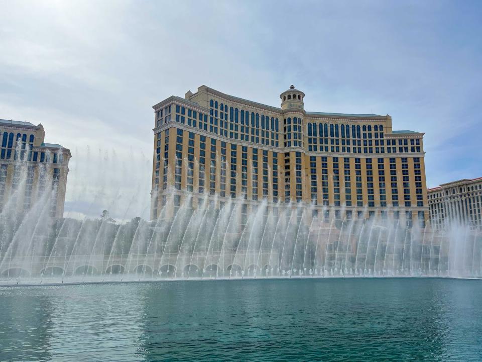 Bellagio fountains, with water shooting upward, in front of brown hotel buildings in Las Vegas