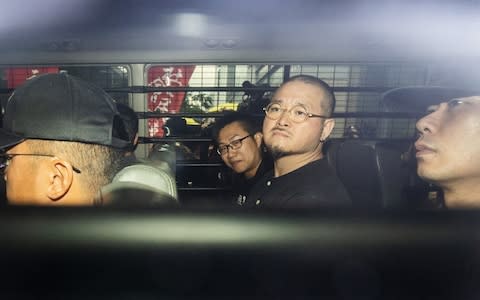 Raphael Wong, center left, and Shiu Ka-chun, center right, sit in a van as they leave court following their sentencing on Wednesday - Credit: Justin Chin/Bloomberg