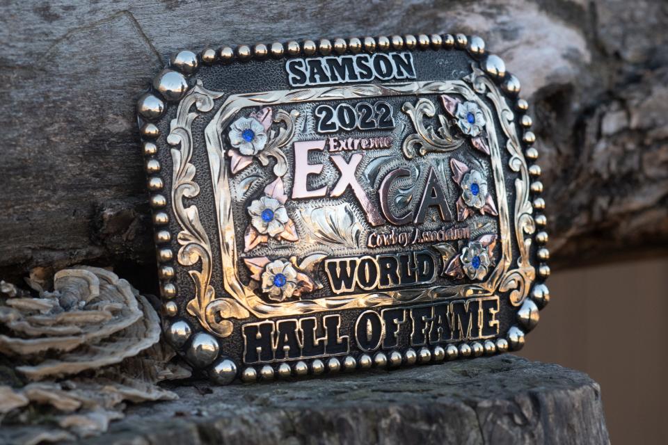 Samson's buckle for his World Hall of Fame title from the Extreme Cowboy Association sits on a piece of wood at Angeline Saliceti's family home.