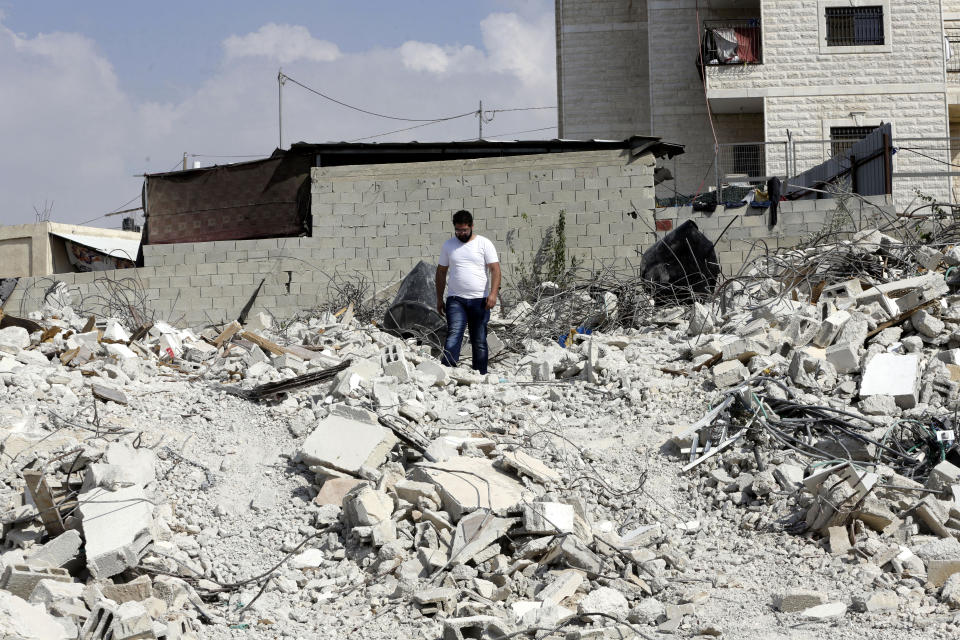 In this Monday, Sept. 9, 2019 photo, Palestinian Jihad Rajabi walks on the rubble of his house that was demolished by Israeli authorities, in the east Jerusalem neighborhood of Beit Hanina. They only gave him and his extended family of 15 people enough time to salvage some personal belongings before demolishing the 200-square-meter (2,150 square-foot) home. (AP Photo/Mahmoud Illean)