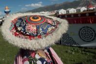 An ethnic Tibetan woman wears a traditional hat at the annual equine festival in Yushu