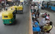 Street dentist Allah Baksh (lower R) treats a customer at his roadside stall at K.R. Market bus stand in Bangalore