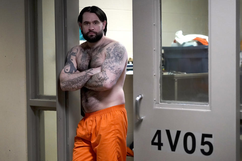Erik Eck posa para una foto en la puerta de su celda de la Cárcel del Condado de DuPage, Illinois, el 3 de febrero del 2022. Eck se acogió a un programa de rehabilitación de pandilleros en el cual deben borrarse o tapar todos sus tatuajes. (AP Photo/Charles Rex Arbogast)
