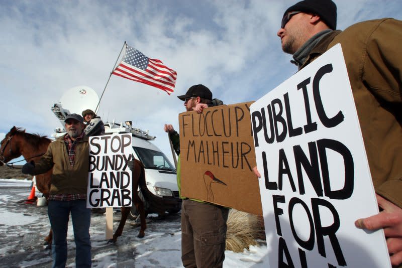 L-R, biologists Kieran Suckling, Cody Martz and Taylor McKinnon hold protest signs at the Malheur National Wildlife Reserve on January 16, 2016, in Burns, Ore. On February 11, 2016, the last four remaining armed occupiers at the refuge surrendered after a 41-day standoff that left one dead. File Photo by Jim Bryant/UPI