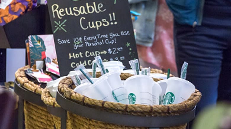 A basket of reusable cups for sale at a Starbucks