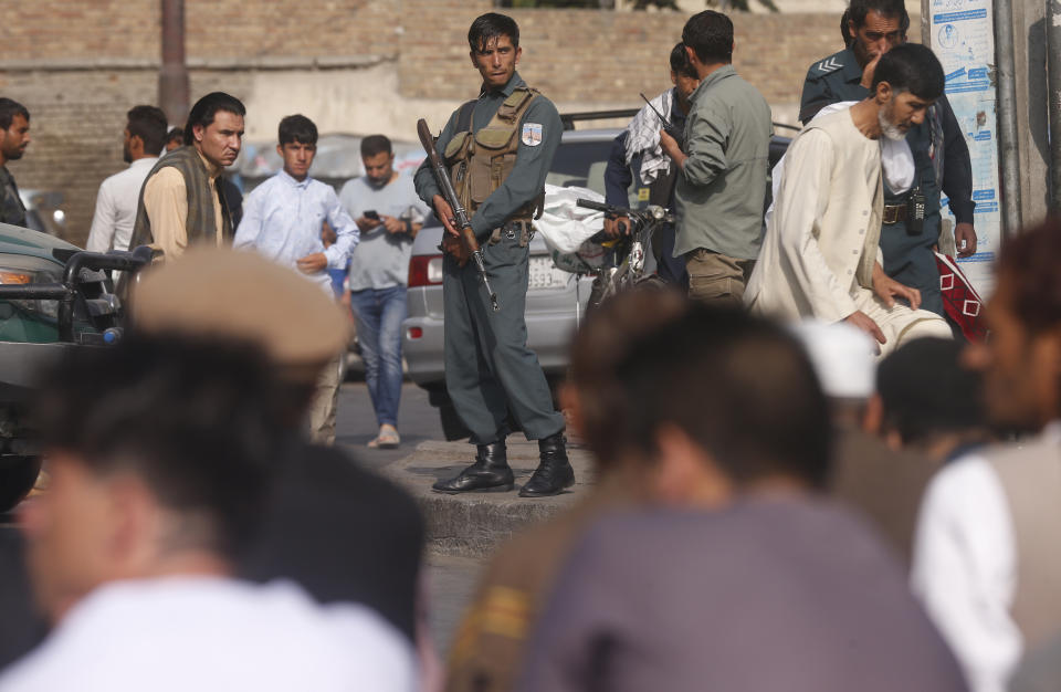 A policeman stands guard as Afghan Muslims attend Eid al-Adha prayers in Kabul, Afghanistan, Sunday, Aug. 11, 2019. Muslim people in the country celebrate Eid al-Adha, or the Feast of the Sacrifice by slaughtering sheep, goats and cows whose meat will later be distributed to the poor.(AP Photo/Rafiq Maqbool)