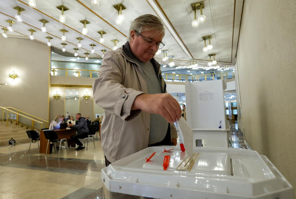 Wähler wirft Stimmzettel in eine Wahlurne in einem Moskauer Wahllokal 