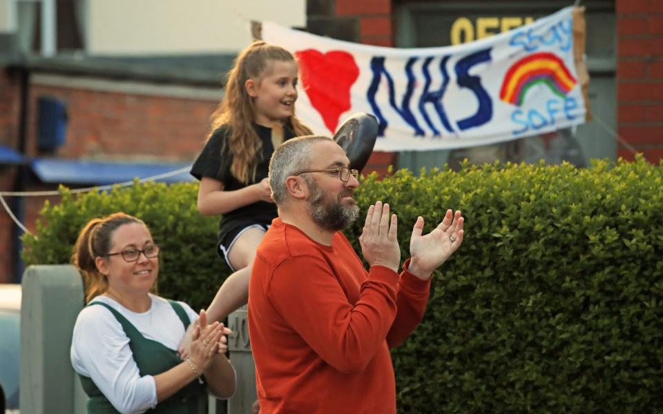 Richard and Samantha Stretton and their daughter, Macey-Mae, clap for carers in Whitley Bay - Owen Humphreys/PA