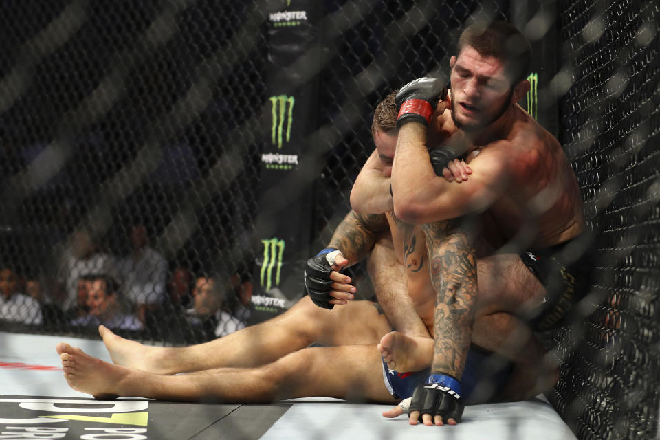 Russian UFC fighter Khabib Nurmagomedov, choke holds UFC fighter Dustin Poirier, of Lafayette, La., during Lightweight title mixed martial arts bout at UFC 242, in Yas Mall in Abu Dhabi, United Arab Emirates, Saturday , Sept.7 2019. (AP Photo/ Mahmoud Khaled)