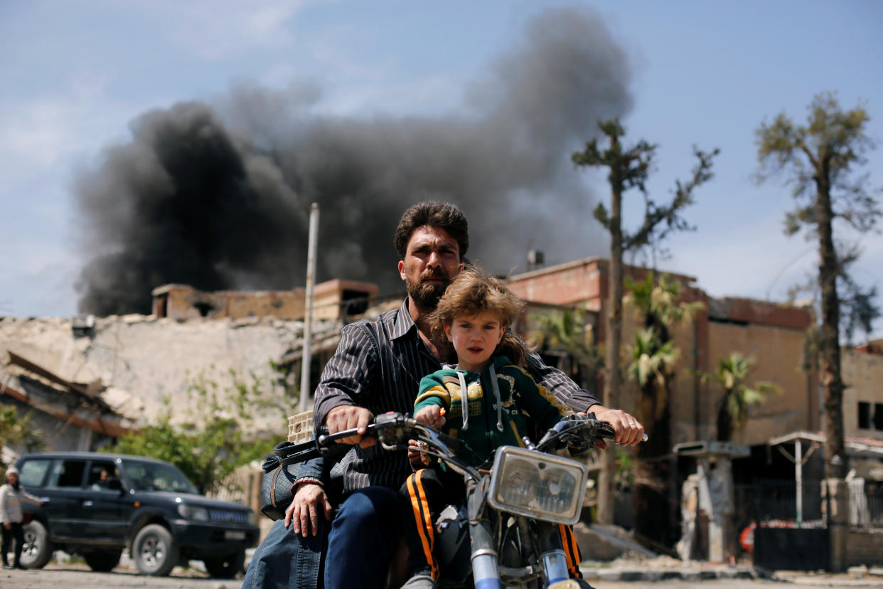 A man and a boy ride a motorbike at the city of Douma in Damascus, Syria, April 16, 2018.&nbsp; (Photo: Omar Sanadiki / Reuters)