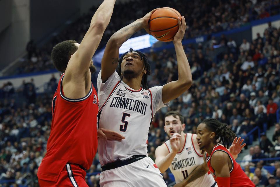 UConn's Stephon Castle (5) shoots against St. John's Chris Ledlum, left, during the first half of an NCAA college basketball game, Saturday, Dec. 23, 2023, in Hartford, Conn. (AP Photo/Michael Dwyer)