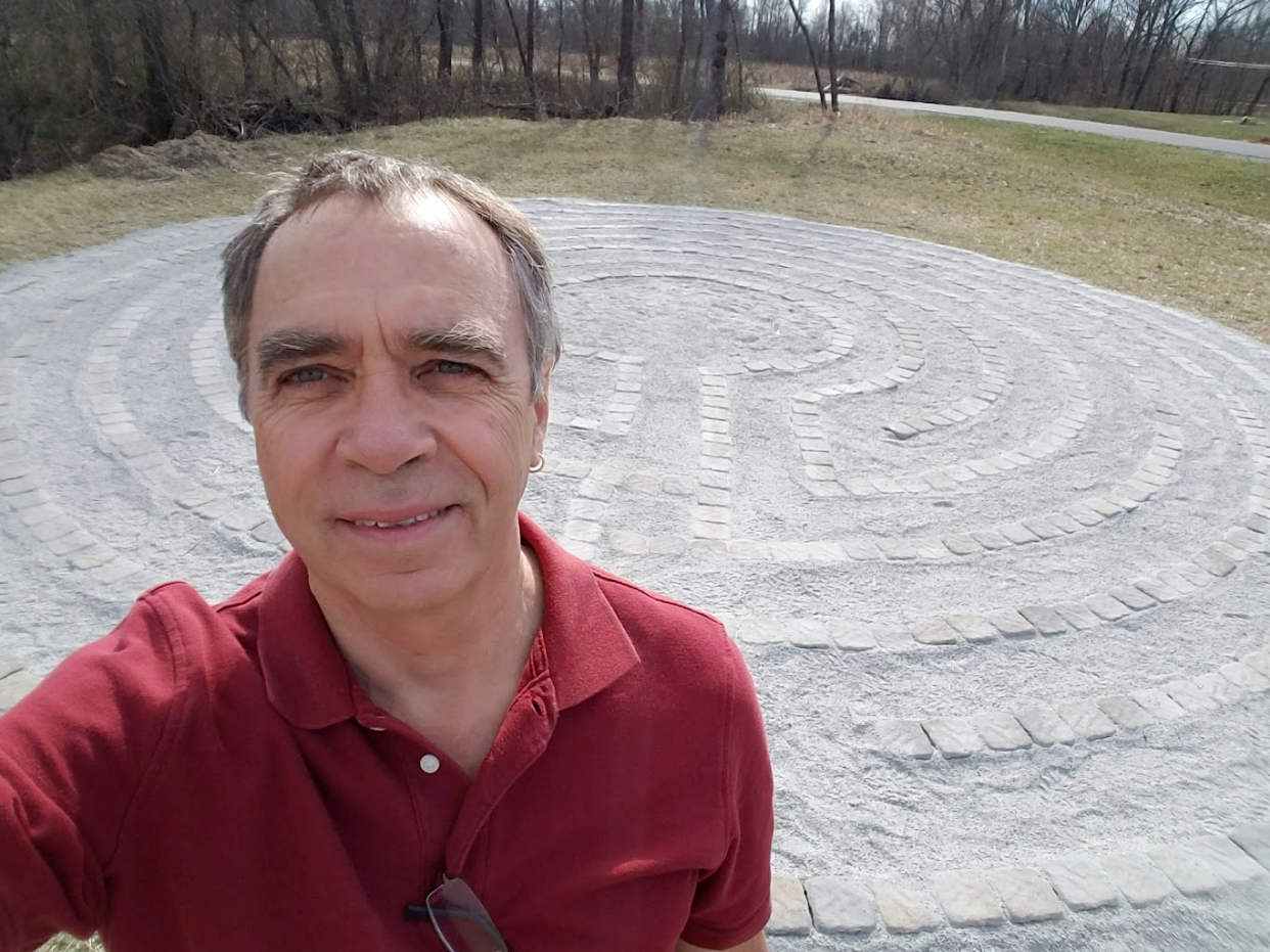 Chuck Hunner labyrinth poses with a labyrinth he helped create at Fern Leaf School in Fletcher.