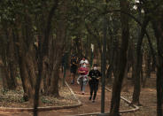 People wearing protective face mask as a precaution against the spread of the new coronavirus jog at Chalputepec park in Mexico City, Sunday, April 26, 2020. (AP Photo/Fernando Llano)