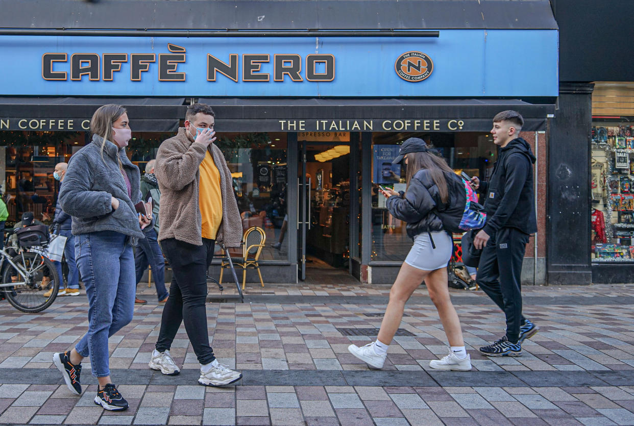 Shoppers wearing face masks walk past Cafe Nero coffee shop. (Photo by Michael McNerney / SOPA Images/Sipa USA)