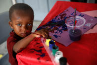 <p>A Barbuda boy paints in a shelter in Antigua for those forced to leave the island just after a month after Hurricane Irma struck the Caribbean islands of Antigua and Barbuda, October 7, 2017. REUTERS/Shannon Stapleton </p>