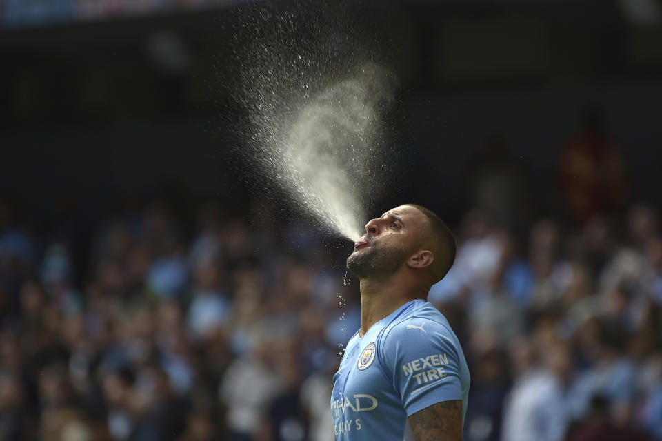 Kyle Walker, del Manchester City, arroja agua por la boca antes del partido de la Liga Premier ante el Arsenal, el sábado 28 de agosto de 2021 (AP Foto/Rui Vieira)