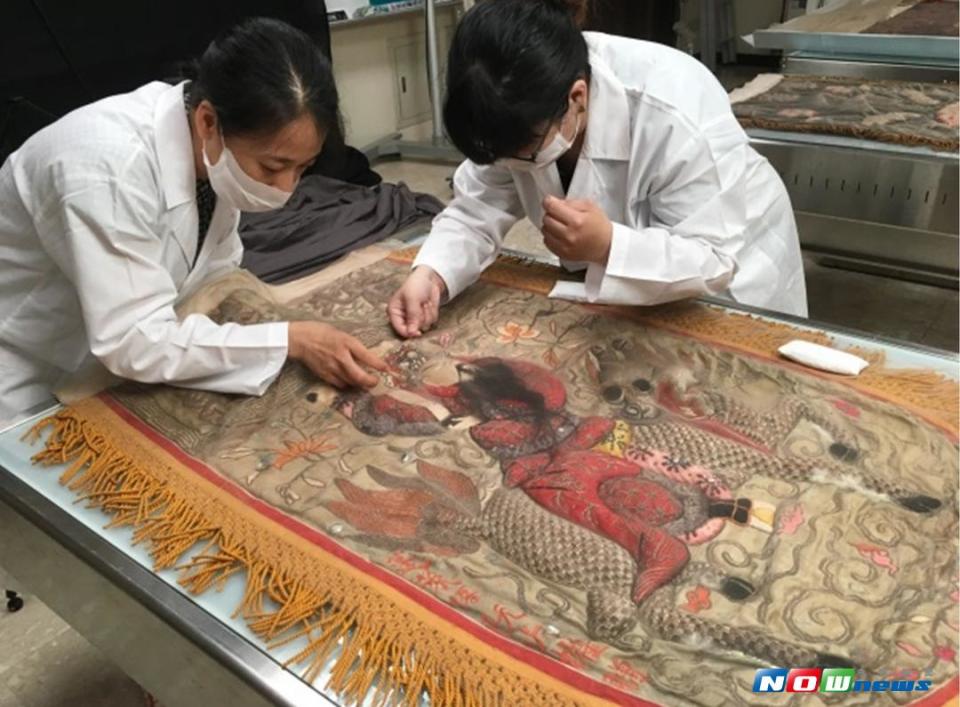 日治時期「北港集雅軒聞太師牛舌旗」於全球刺繡研究發展中心進行暫時性加固作業。（圖／記者蘇榮泉翻攝，2017.08.17）