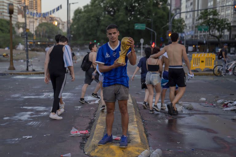 La camiseta Le Coq Sportif y la copa del mundo en manos de un hincha