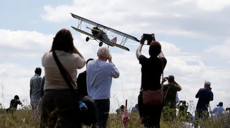 A biplane flies over spectators during the Vintage Air Rally at the Nairobi national park in Kenya's capital Nairobi, November 27, 2016. REUTERS/Thomas Mukoya