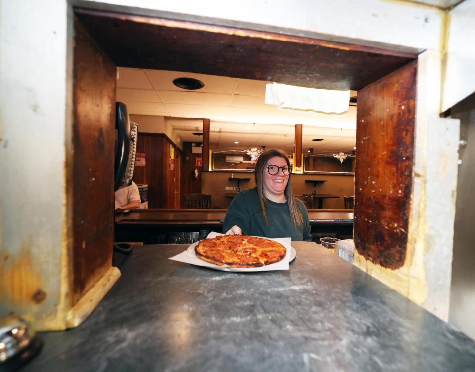 Bartender Emily Armstrong brings a pizza order to a customer at Venus Cafe in Whitman on Tuesday, Feb. 6, 2024.