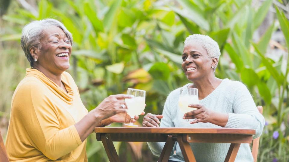 older women having drinks together outside