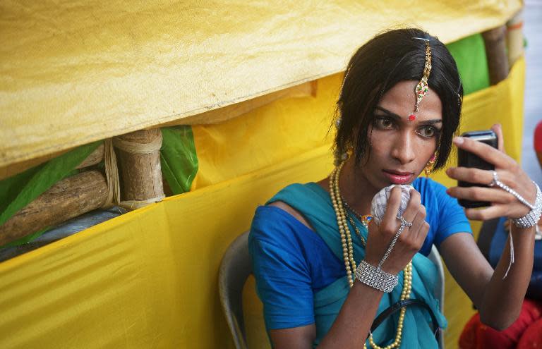 An Indian transgender dancer puts on makeup before a performance for a function in Kolkata on April 30, 2013