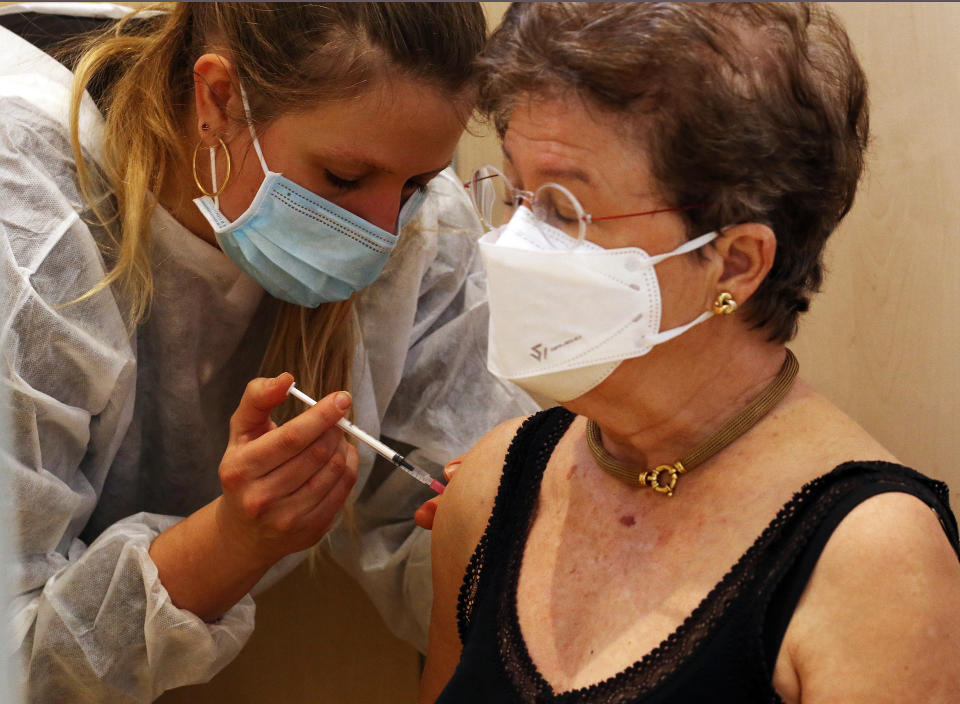 A woman receives the Pfizer-BioNTech vaccination against COVID-19 at a vaccination center in Bayonne, southwestern France, Monday, Jan. 18, 2021. French health authorities, who have been concerned over polls showing the majority of French were wary of vaccines against COVID-19, may have had a surprise with the number of people who have signed up for shots starting Monday, reserved for those 75 and older or with a high health risk. (AP Photo/Bob Edme)