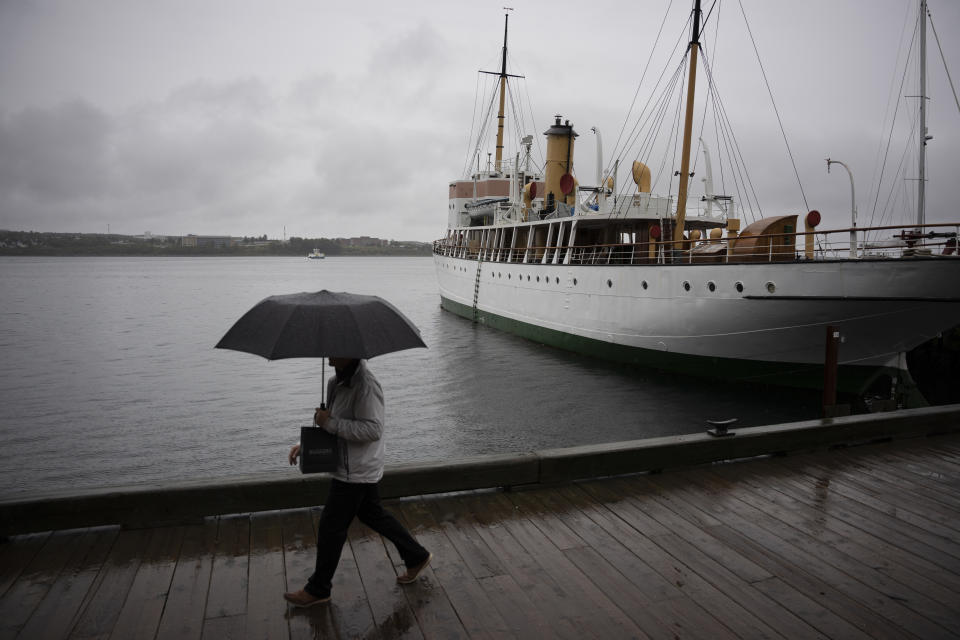 Una persona se resguarda bajo un paraguas junto al mar, en Halifax, antes de la llegada del huracán Fiona a la ciudad canadiense, el 23 de septiembre de 2022. (Darren Calabrese /The Canadian Press vía AP)