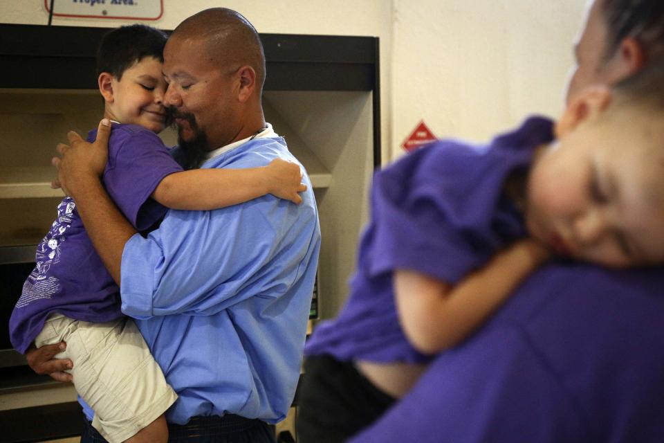 Adrian Navarro holds his sonat the end of a "Get On the Bus" visiting day to Folsom State Prison