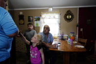 Daniel Guess, left, talks to his family grandchildren Avery Moore, 4, center, Cayden Moore, 8, and father Larry Guess in the kitchen on Thursday, June 23, 2022, in Athens, Ala. Daniel's brother, David Guess, 51, was killed by gun violence in March. Guess’ death began with an argument over a car part. (AP Photo/Brynn Anderson)