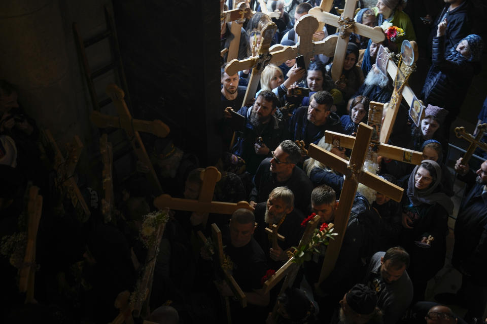 Orthodox Christian worshippers carry crosses during the Good Friday procession at the Church of the Holy Sepulcher, where many Christians believe Jesus was crucified, buried and rose from the dead, in Jerusalem's Old City, Friday, April 14, 2023. (AP Photo/Ariel Schalit)