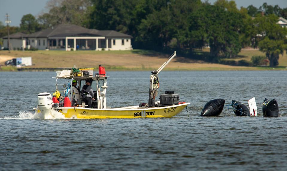 Recovery crews tow the Piper PA-28 Cherokee to the shore of Lake Hartridge in Winter Haven on Thursday.