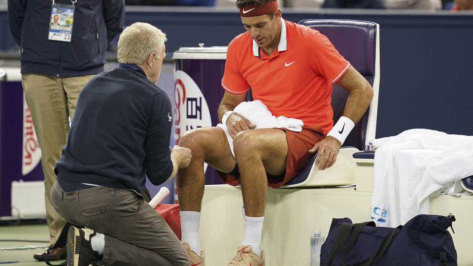 Juan Martin del Potro talks to the trainer as he is forced to retire. (Photo by Fred Lee/Getty Images)