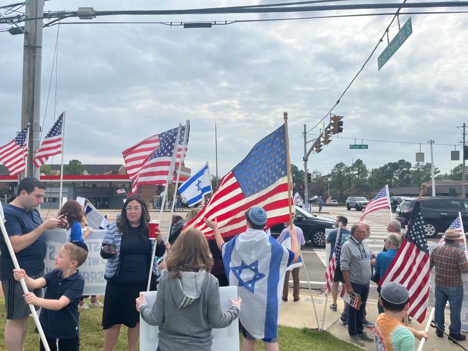 Protesters hold American and Israeli flags as cars drive by, honking in support of Israel in Memphis, Tenn. on Sunday, October 29, 2023.