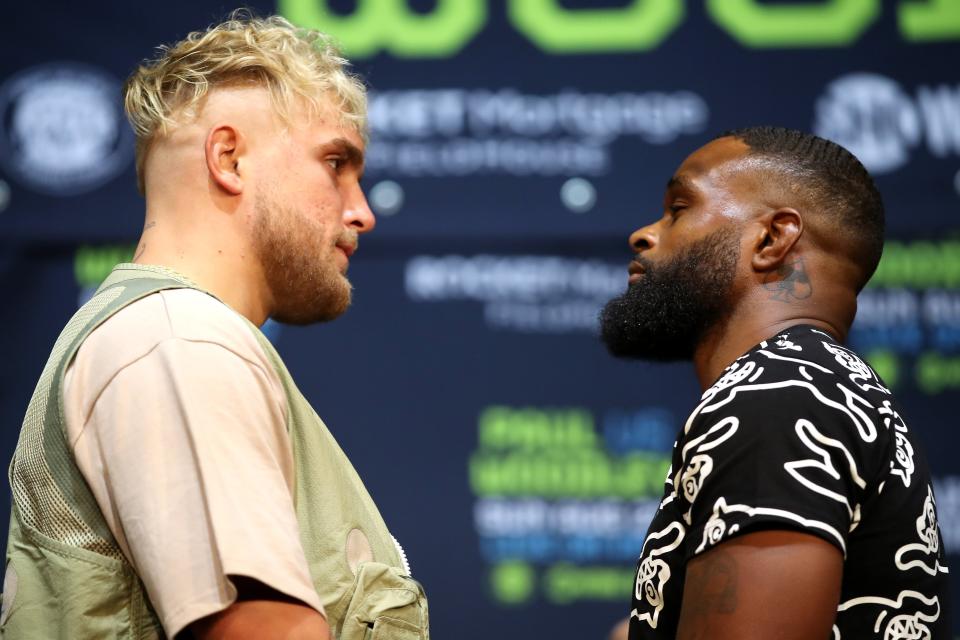 Jake Paul, left, and Tyron Woodley face off during a news conference.