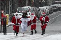 Three revellers dressed as Santa Claus run in park during the SantaCon event in New York December 14, 2013. Every year since 1997, thousands of men and women have dressed up as Santas, elves, reindeer or some other holiday confection and descended on the city's streets for a daylong bar crawl that begins with good cheer and, for many, inevitably ends in a blurry booze-soaked haze. Many come from Long Island and New Jersey, getting a head start on the festivities on the train ride into the city. REUTERS/Eduardo Munoz (UNITED STATES - Tags: SOCIETY ENTERTAINMENT TPX IMAGES OF THE DAY)