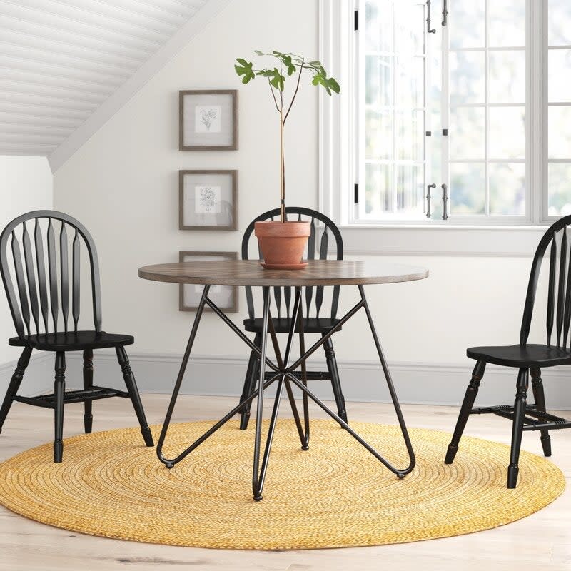 the dining table with black iron legs and a dark wood surface