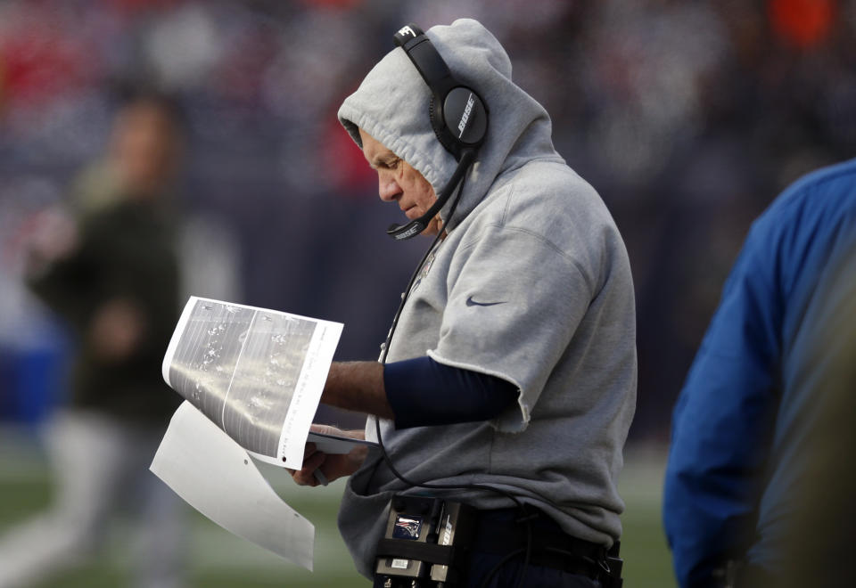 Patriots head coach Bill Belichick reviews photographs on the sideline during the first half of last Sunday’s game against the Miami Dolphins. (AP)