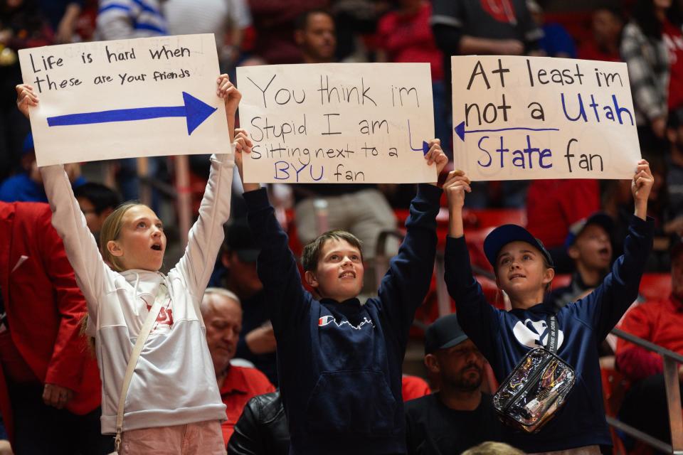 Kids hold signs showing the rivalry between the Brigham Young University and University of Utah before they play against each other in a men’s basketball game at the Jon M. Huntsman Center in Salt Lake City on Saturday, Dec. 9, 2023. | Megan Nielsen, Deseret News